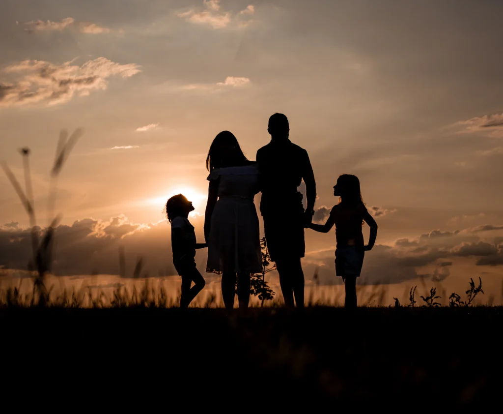 Parents with their two children at sunset, representing families served by Austin divorce and family lawyers